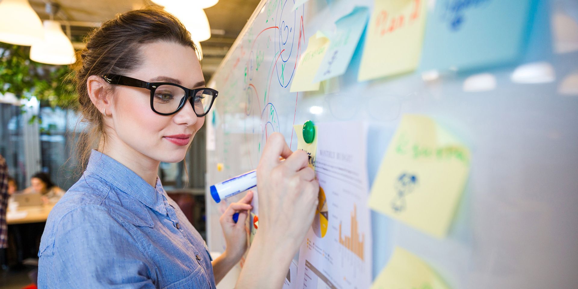 Frau schreibt auf Whiteboard Contentkonzepte